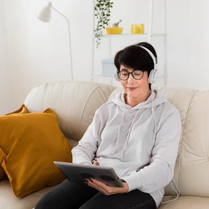 woman sofa with tablet headphones